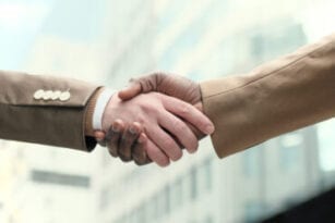 Close-up of business people shaking hands outdoors
